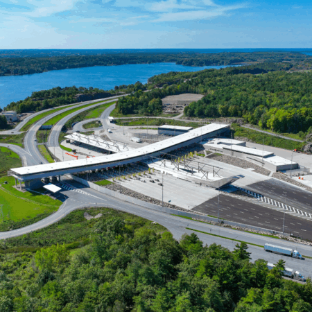 Aerial view of large border crossing by water with greenery.